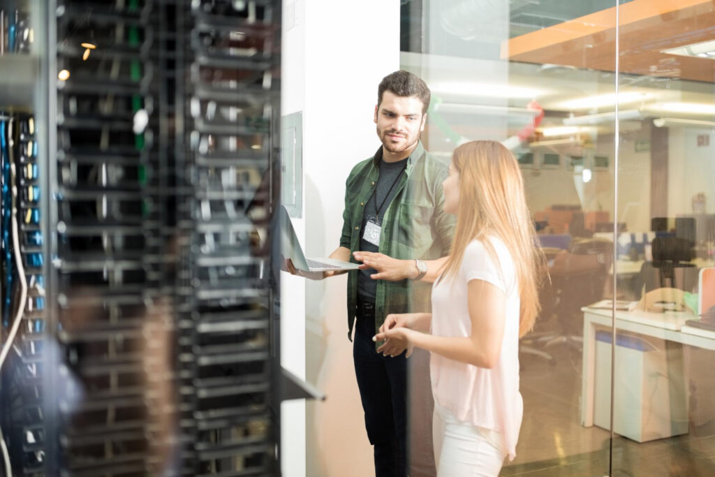 photo de techniciens informatiques échangeant devant des serveurs